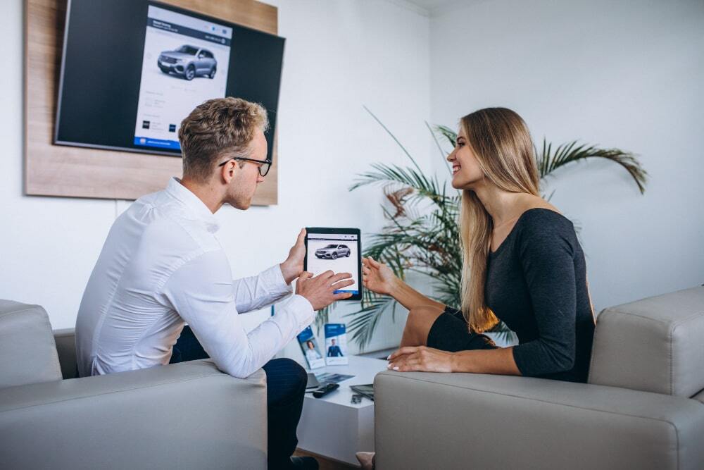 Car Marketing Turn Your Vehicle into a 247 Advertising Machine (A dealer is dealing with client while helping them explore more options and how they can use their car)