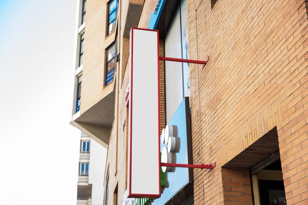 Image showing a signage board placed above the shop in vertical way for catching eyes of the pedestrians (Strategic Placement for Maximum Impact)