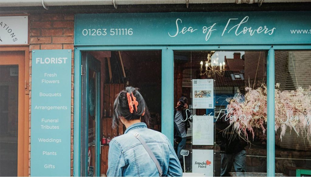 This image is showing a customer being attracted to a shop from its outdoor sign, referring to the Benefits of Using Interactive Outdoor Signs