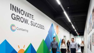 Office hallway wall branding with large text "INNOVATE. GROW. SUCCEED." and abstract mountain graphics.