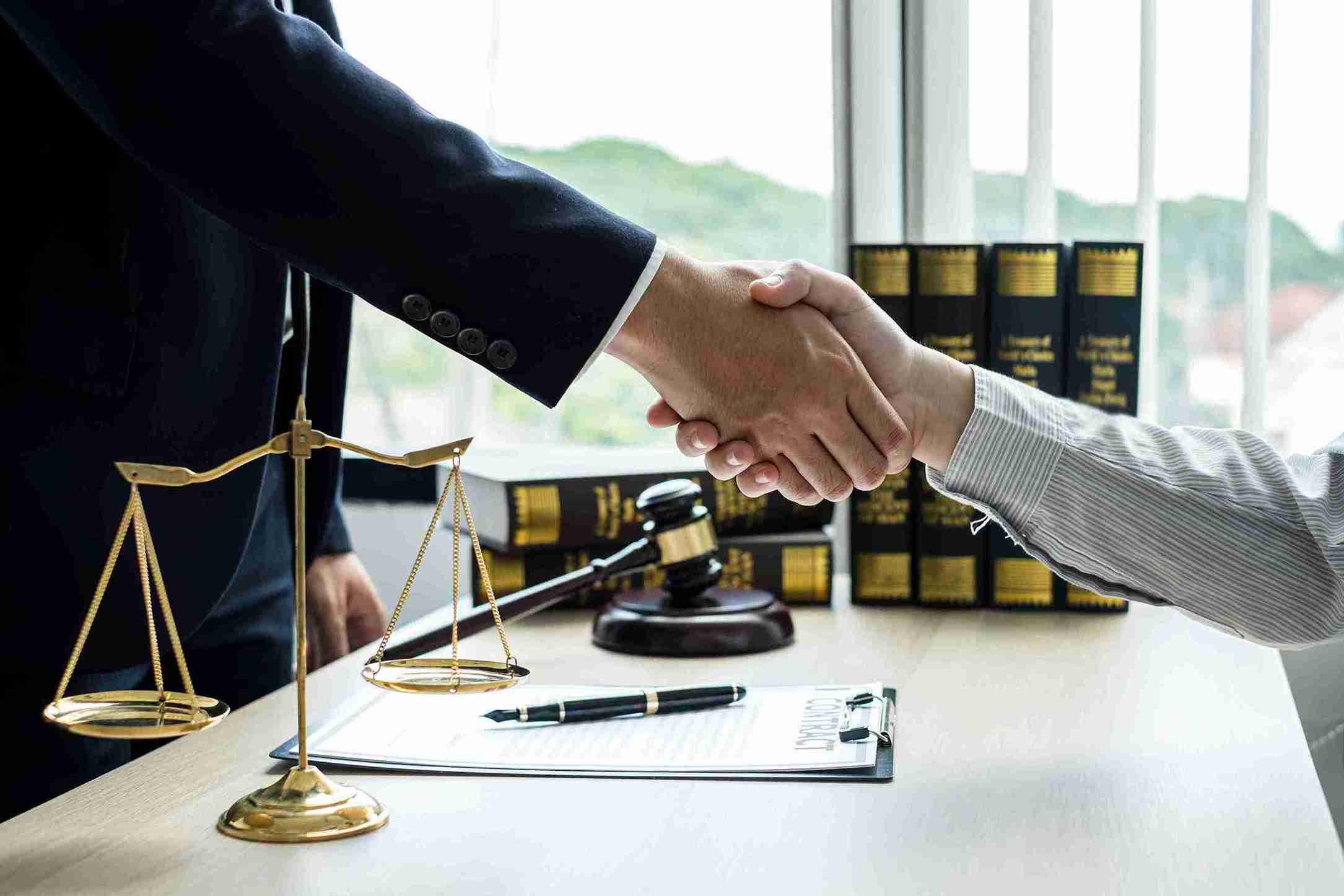 A lawyer is shaking hand with client upon successful case.